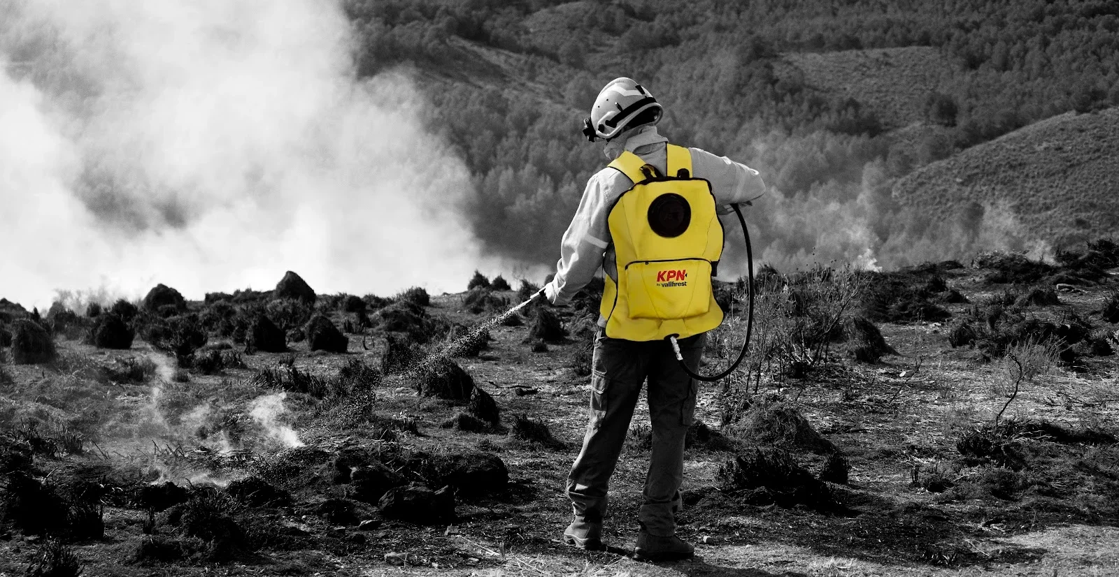 Brigadista usando mochila extintora KPN em área de vegetação